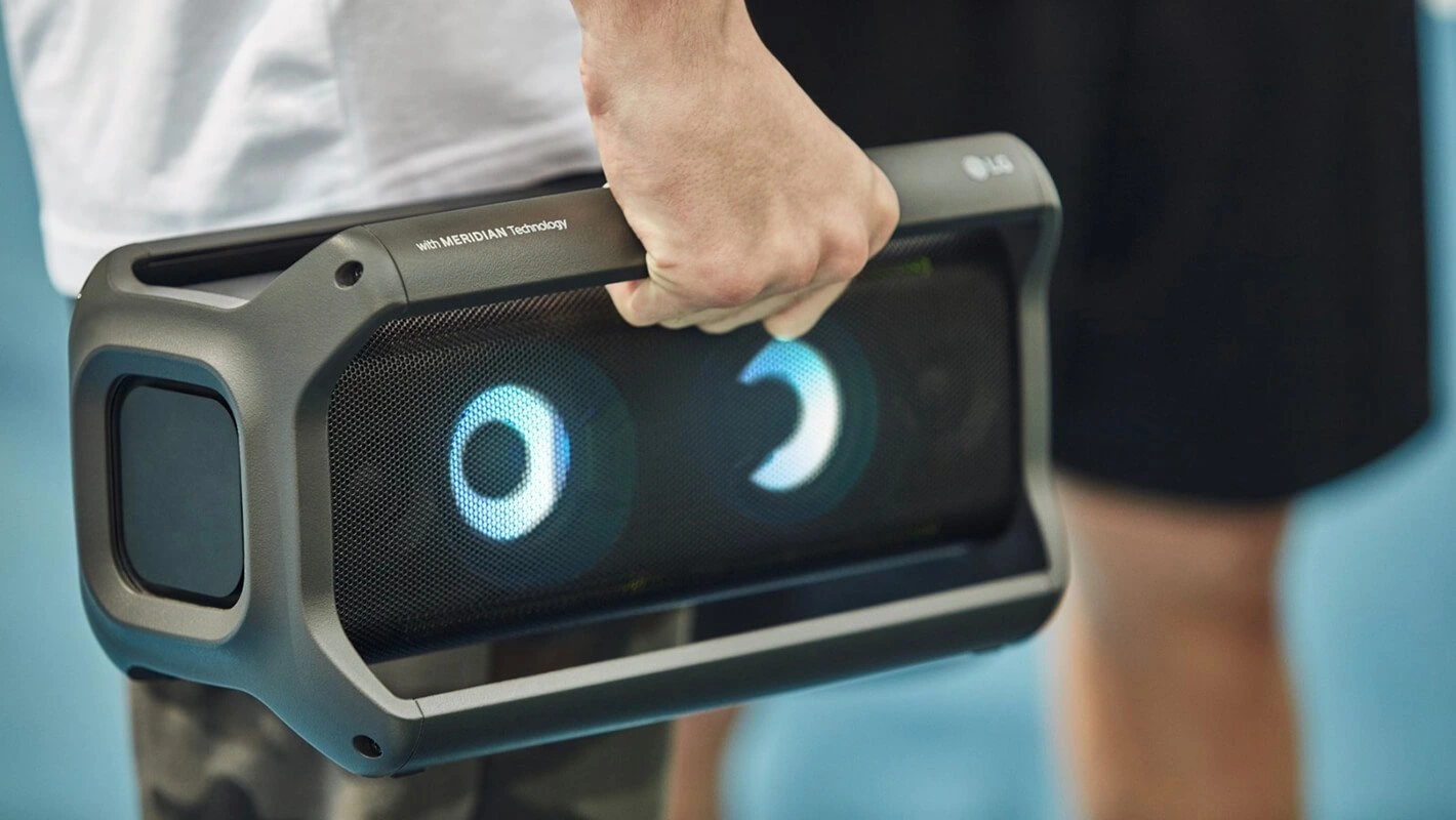 LG Xboom Go transportada pela alça em situação de uso